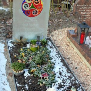 Artistiek glazen grafmonument met gekleurde cirkel voor kind