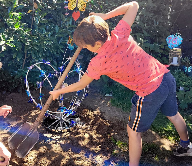 jongen met schep bij graf