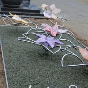 Modern RVS grafmonument met glazen bloemen voor jonge vrouw