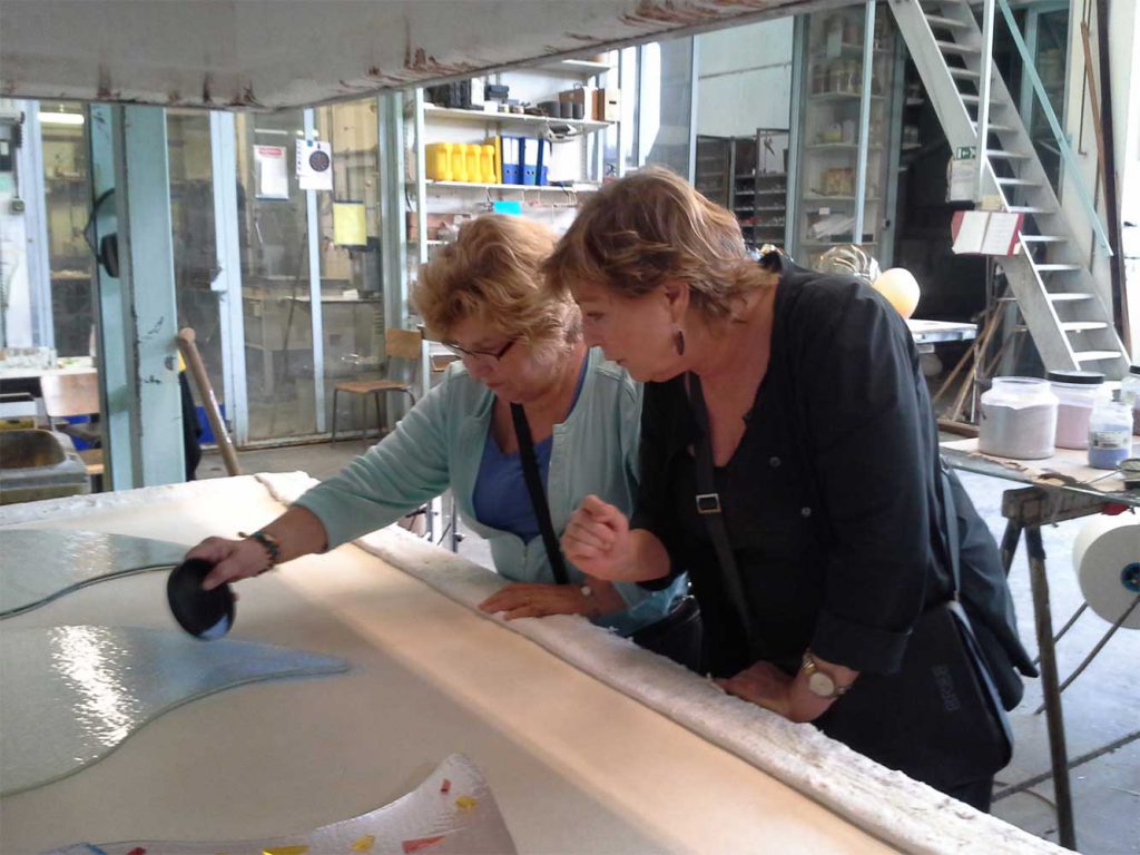 Werk aan kleurrijk grafmonument van glas met harten voor partner en ouder