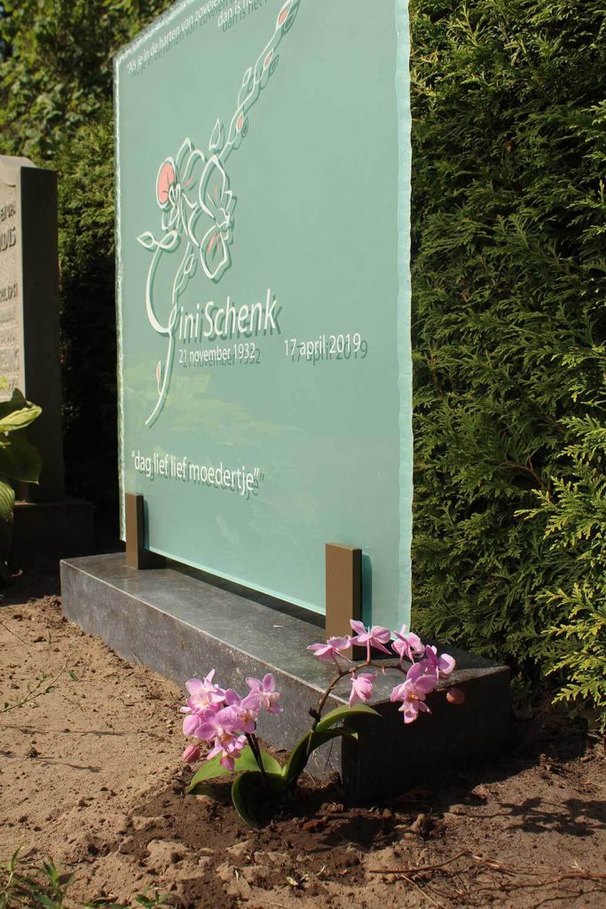 orchidee bij glazen grafsteen