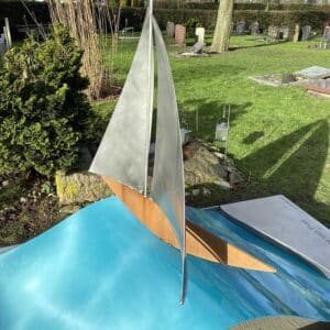 laat winter zonlicht op zeilbootje op blauwe golf - een wel heel apart grafmonument